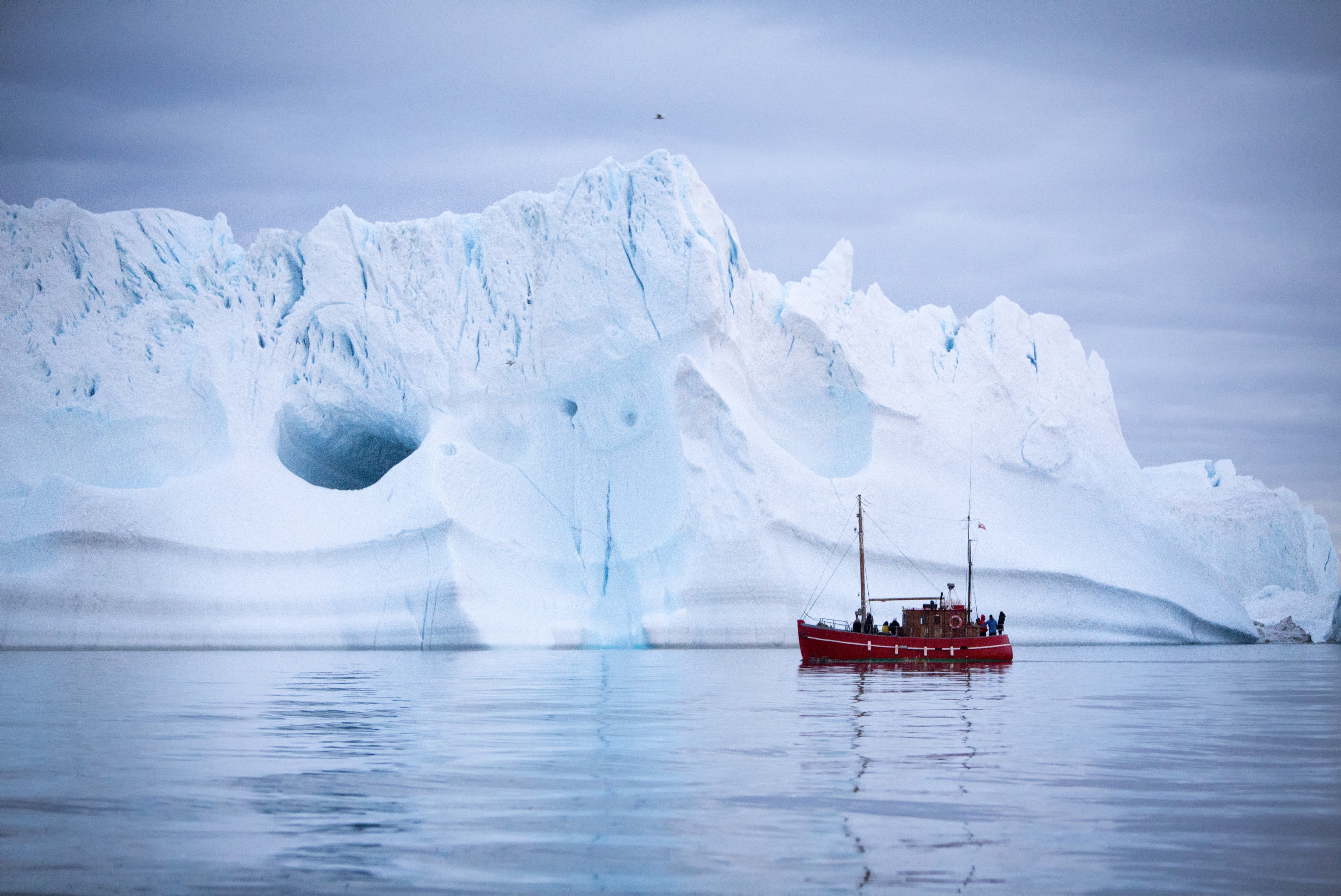 Tourists on a boat tour sailing by a giant iceberg near Ilulissat in North Greenland - Photographer: