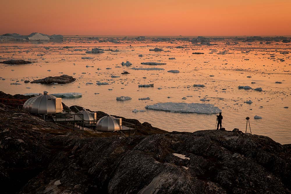 A Photographer In The Sunset Near Hotel Arctic In Ilulissat In Greenland