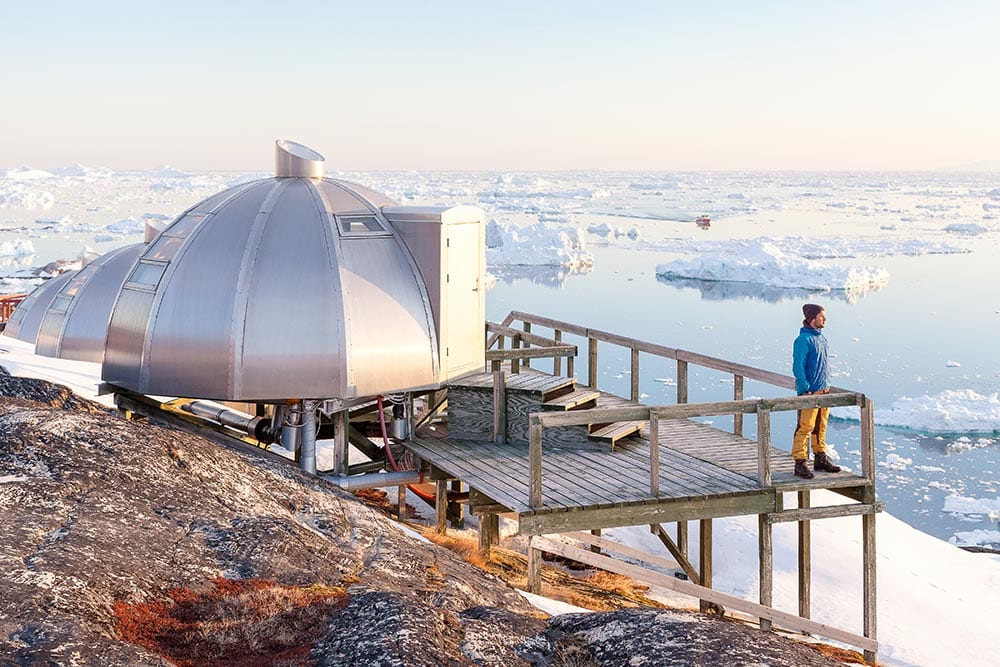Foto: a-traveler-enjoying-the-view-from-the-igloo-viewpoint-at-hotel-arctic-near-the-ice-fjord-in-ilulissat A Traveler Enjoying The View From The Igloo Viewpoint At Hotel Arctic Near The Ice Fjord In Ilulissat