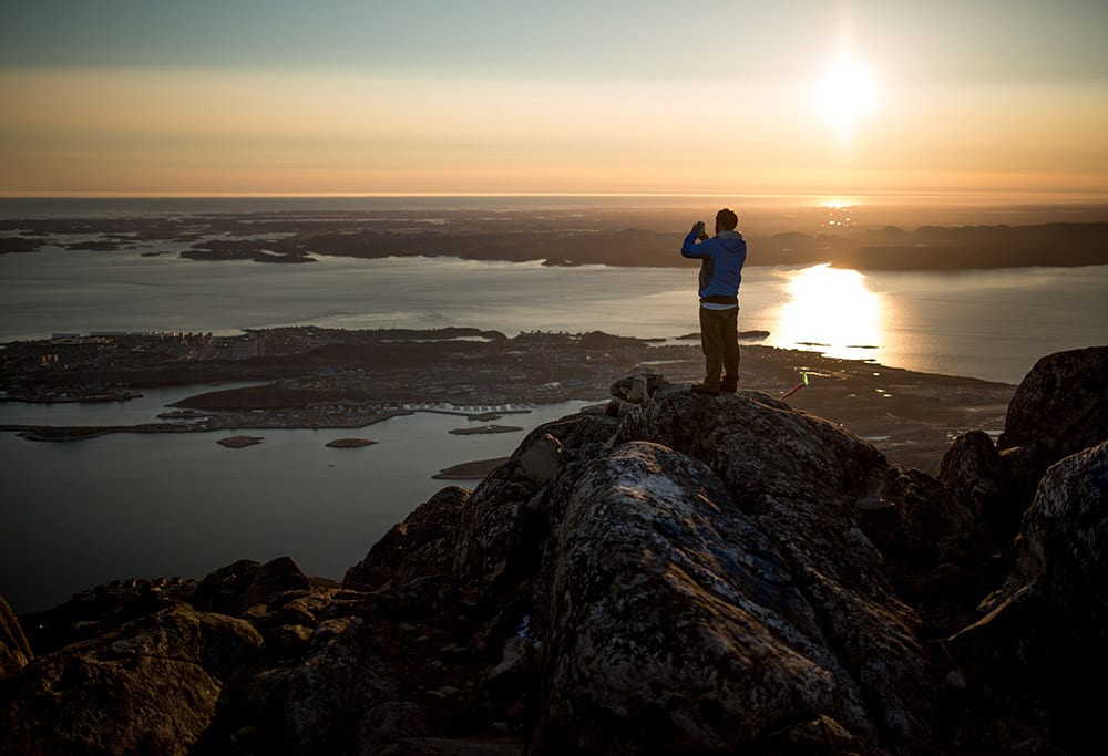 A Hiker Photographing Nuuk From The Peak Of Store Malene Ukkusissaq In Greenland